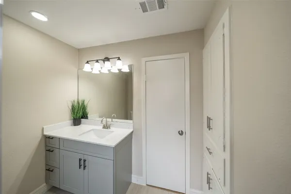 a bathroom with a sink vanity and a mirror