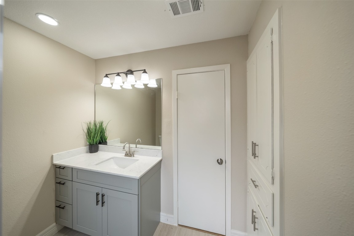355 Windsor Square Alvin, TX 77511 - Photo 17 of 22 This bathroom features a modern vanity with a sleek countertop, a large mirror, and stylish lighting. It includes built-in storage cabinets and a neutral color palette for a clean, inviting look.