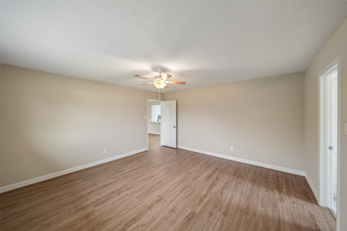 355 Windsor Square Alvin, TX 77511 - Photo 19 of 22 Spacious bedroom with light wood flooring, neutral walls, and ceiling fan. Room connects to additional space, offering flexibility and comfort.
