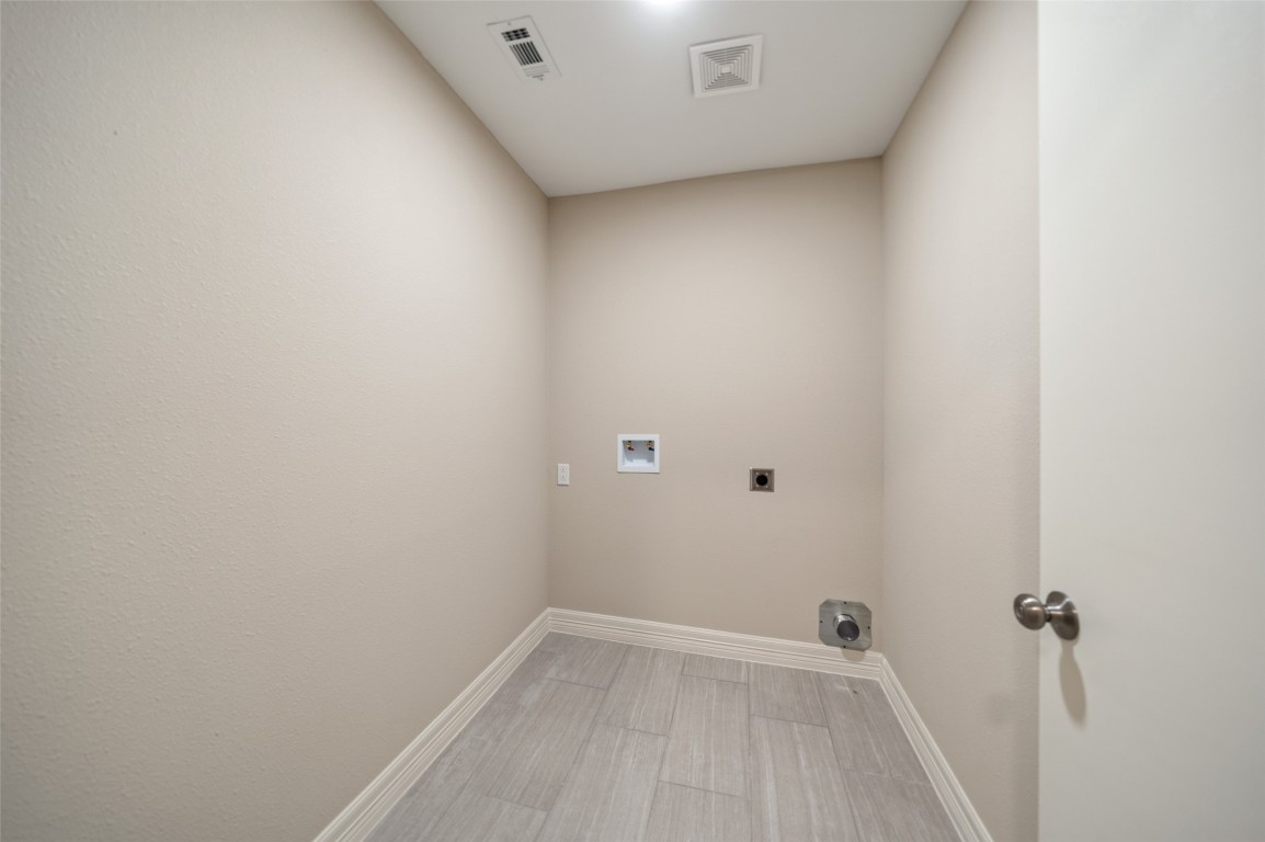 355 Windsor Square Alvin, TX 77511 - Photo 20 of 22 This is a utility room with hookups for a washer and dryer. It features neutral walls, a tile floor, and a ceiling vent.