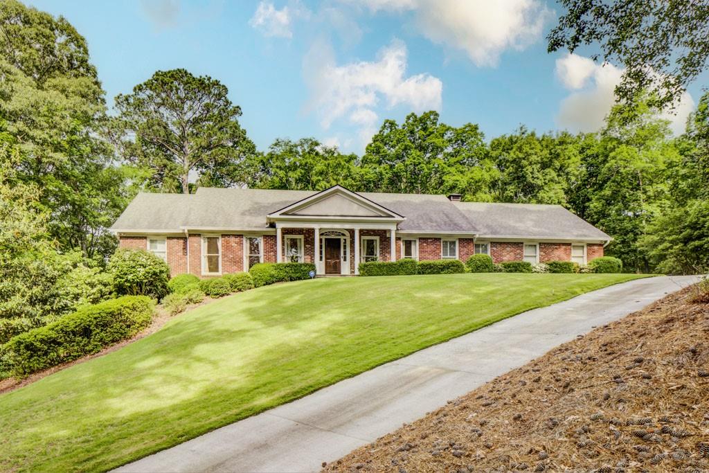a aerial view of a house next to a big yard and large trees
