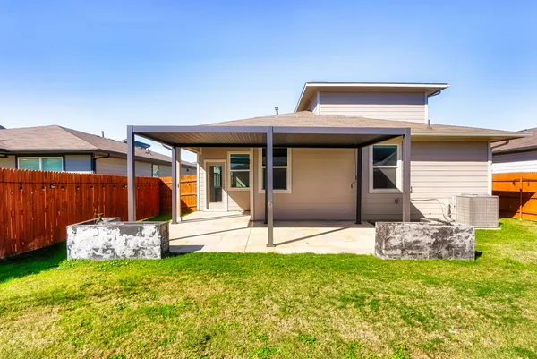 a backyard of a house with table and chairs
