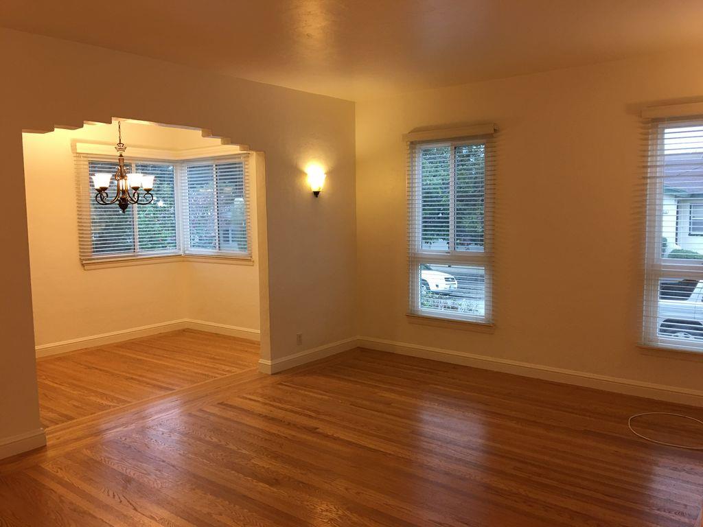 1217 Capuchino Avenue, Unit 1 Burlingame, CA 94010 - Photo 1 of 10 a view of an empty room with a window and wooden floor