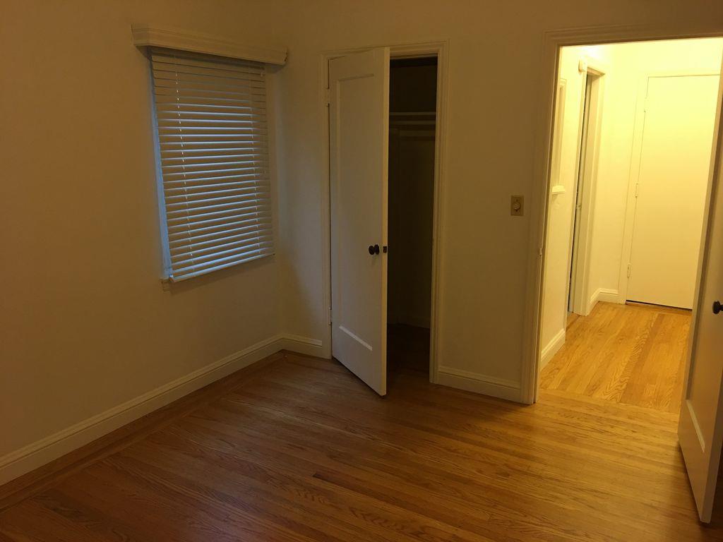 1217 Capuchino Avenue, Unit 1 Burlingame, CA 94010 - Photo 7 of 10 a view of an empty room with wooden floor and a window