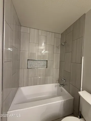 a bathroom with a granite countertop sink a toilet and shower