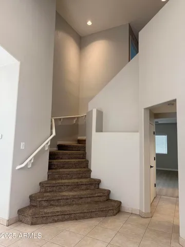 a kitchen with stainless steel appliances granite countertop a stove top oven a sink a refrigerator and white cabinets