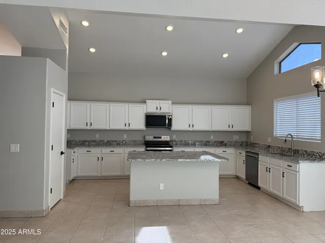a kitchen with stainless steel appliances granite countertop a stove sink and cabinets