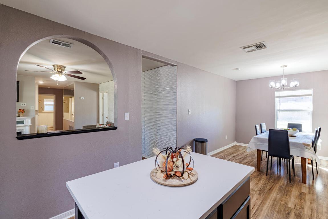 112 Maynard Street Bastrop, TX 78602 - Photo 11 of 35 Dining area with a ceiling fan, light wood-type flooring, a textured wall, and a chandelier