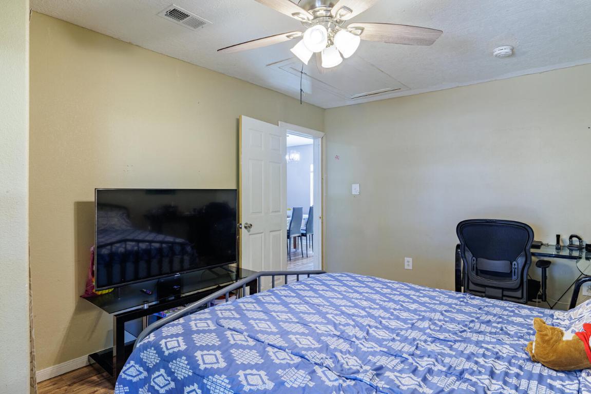 112 Maynard Street Bastrop, TX 78602 - Photo 20 of 35 Bedroom with wood finished floors, a ceiling fan, and a desk