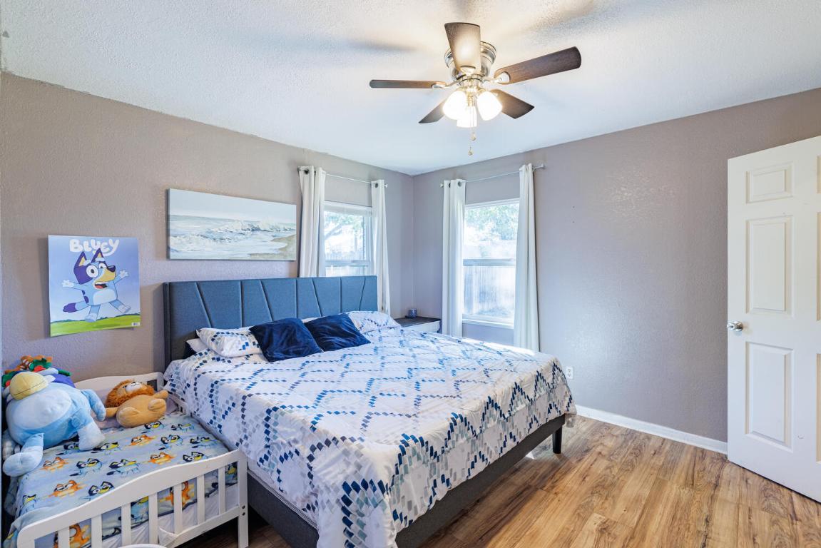 112 Maynard Street Bastrop, TX 78602 - Photo 26 of 35 Bedroom featuring a textured wall, wood finished floors, and ceiling fan