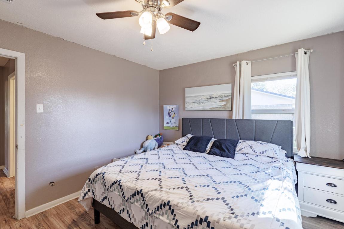 112 Maynard Street Bastrop, TX 78602 - Photo 27 of 35 Bedroom with wood finished floors, a ceiling fan, and a textured wall