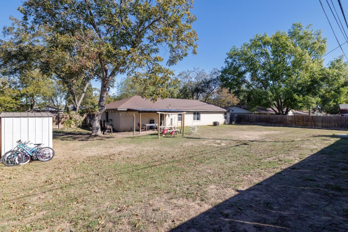 112 Maynard Street Bastrop, TX 78602 - Photo 33 of 35 Back of property featuring a shed, a fenced backyard, and a patio