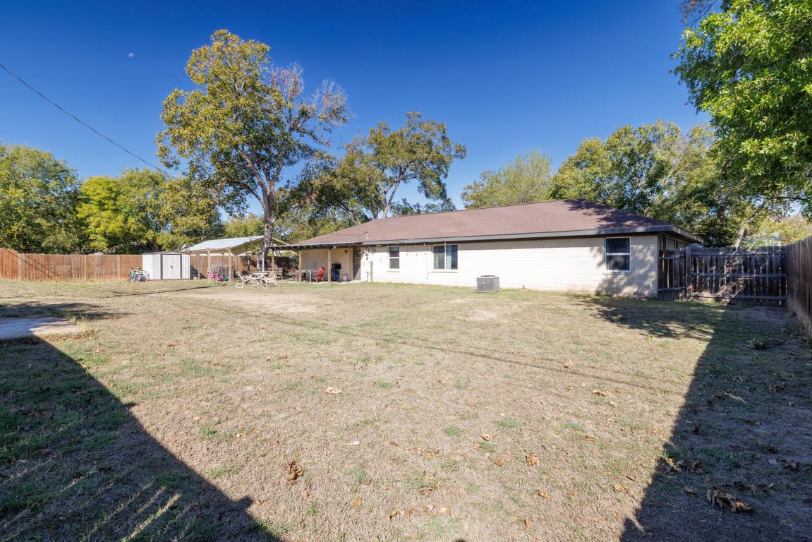 112 Maynard Street Bastrop, TX 78602 - Photo 34 of 35 Rear view of property with a fenced backyard, a storage shed, and a patio area