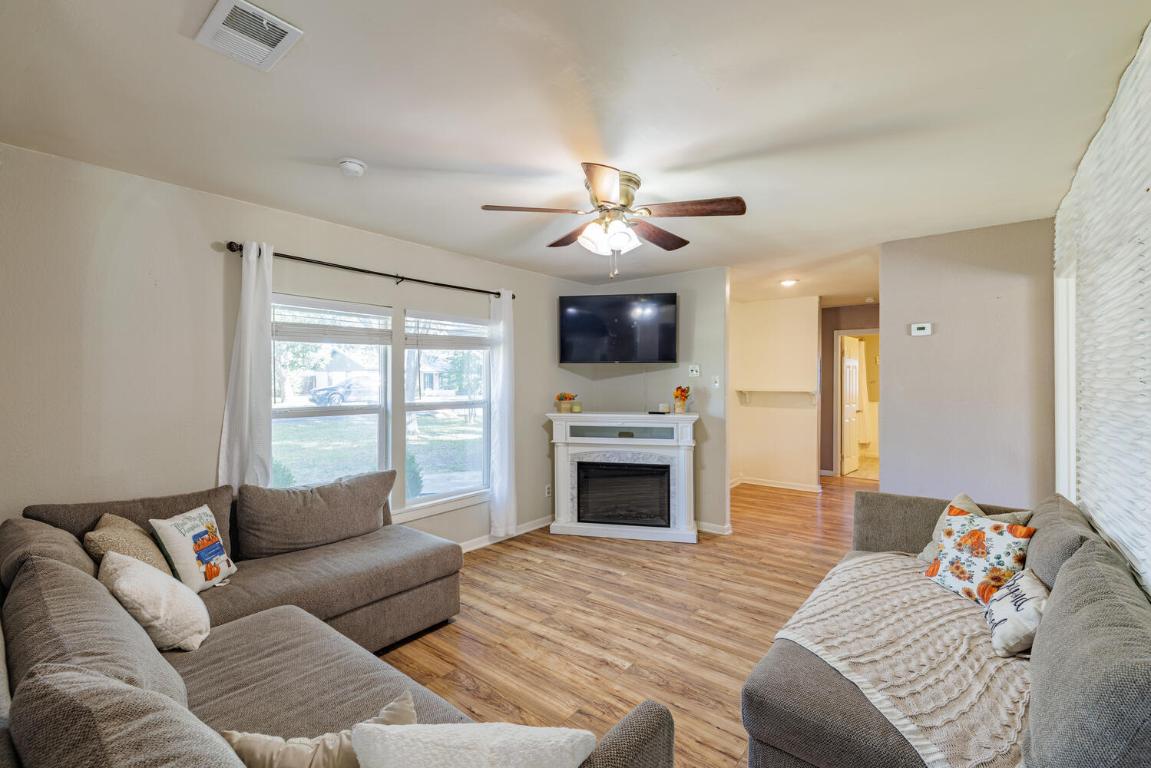 112 Maynard Street Bastrop, TX 78602 - Photo 8 of 35 Living room featuring light wood finished floors, a fireplace, and a ceiling fan