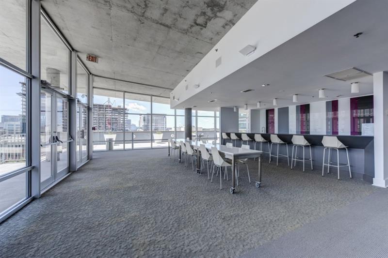 845 Spring Street Northwest, Unit 522 Atlanta, GA 30308 - Photo 13 of 23 a room with lots of tables a large window and chairs