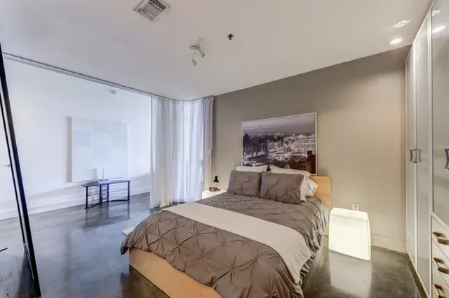 a bedroom with a bed and wooden floor