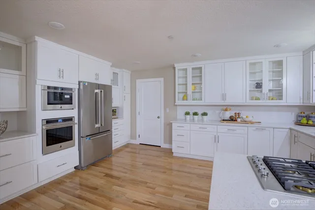 a kitchen with granite countertop a refrigerator and a stove top oven