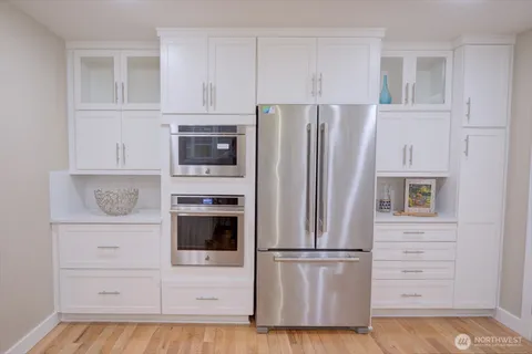 a white refrigerator freezer and a stove sitting inside of a kitchen