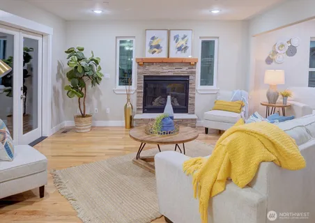 a living room with furniture a fireplace and a potted plant