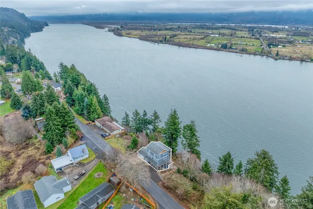 an aerial view of a house with a yard and lake view