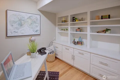a white kitchen with a oven a rug and a potted plant