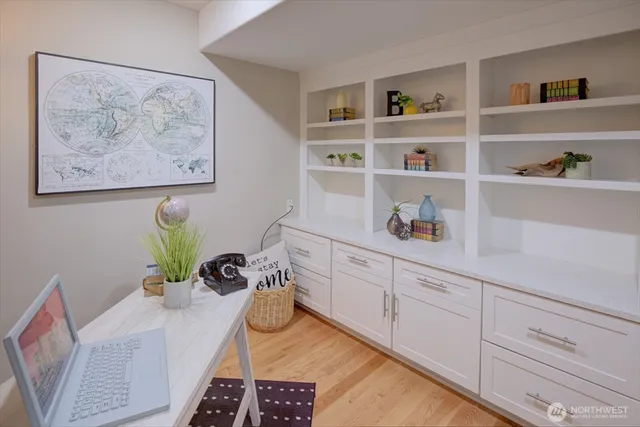 a white kitchen with a oven a rug and a potted plant
