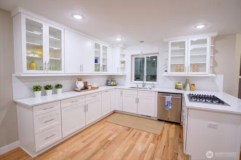 a kitchen with stainless steel appliances granite countertop a stove a sink and a microwave