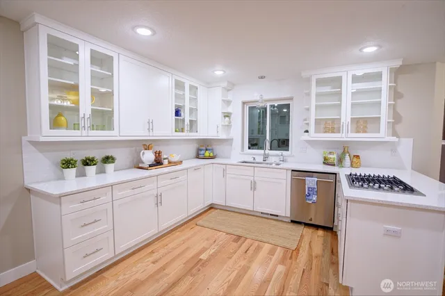 a kitchen with stainless steel appliances granite countertop a stove a sink and a microwave