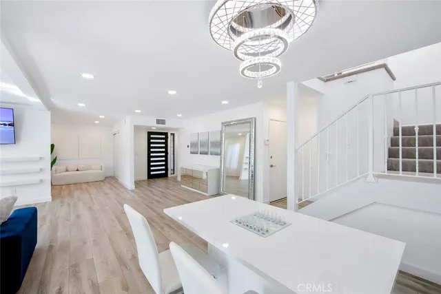 a large white kitchen with a sink and refrigerator