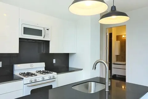 a kitchen with stainless steel appliances a stove a sink and a microwave