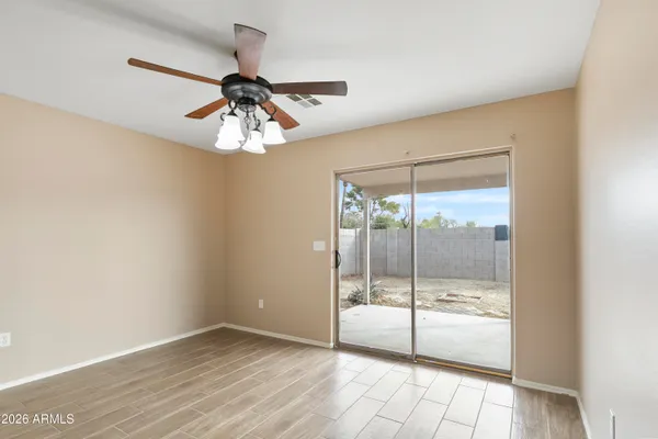 a view of a livingroom with a chandelier fan and a floor to ceiling window