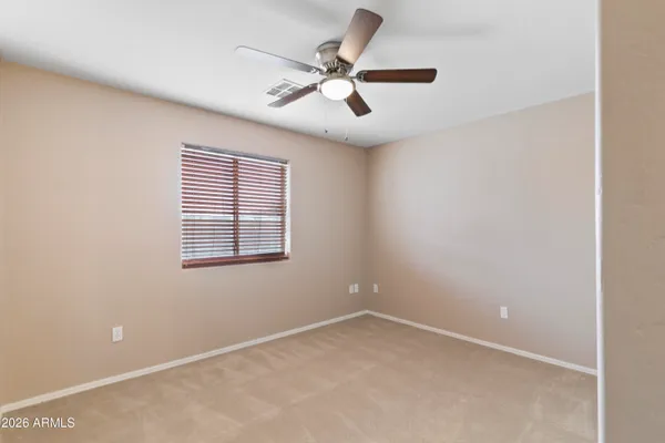 an empty room with a window and a fan