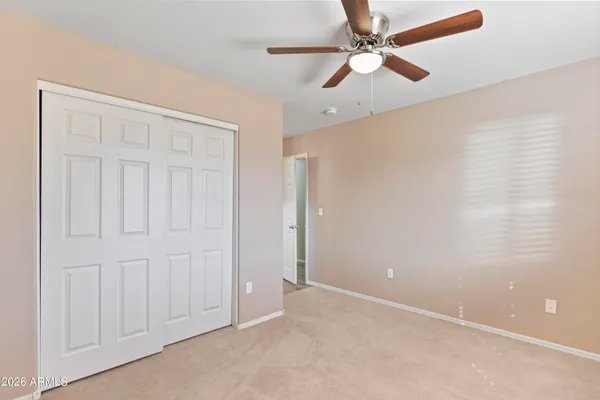 an empty room with windows and fan