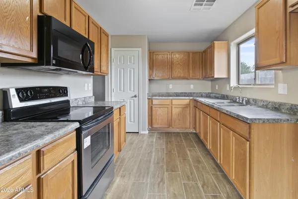 a kitchen with stainless steel appliances granite countertop a sink stove and microwave