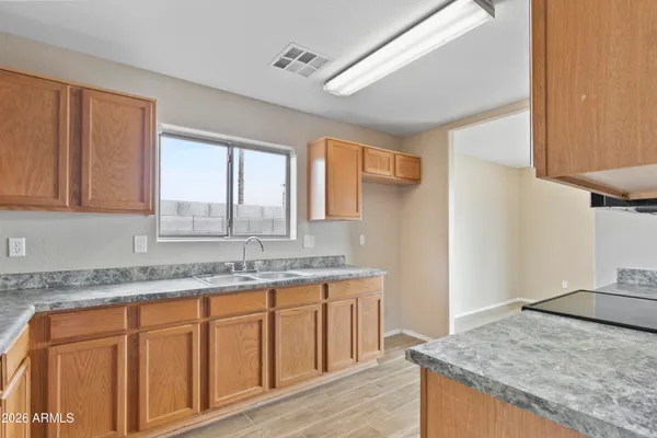 a kitchen with granite countertop a sink a stove and cabinets