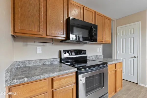 a kitchen with granite countertop wood cabinets and a stove top oven