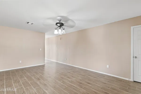 a view of an empty room with wooden floor
