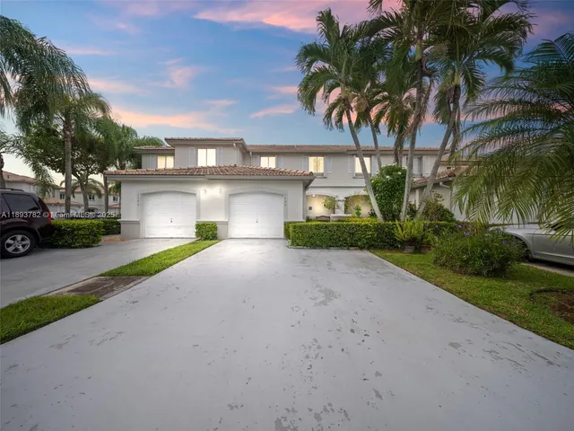 a view of a house with a yard and palm trees