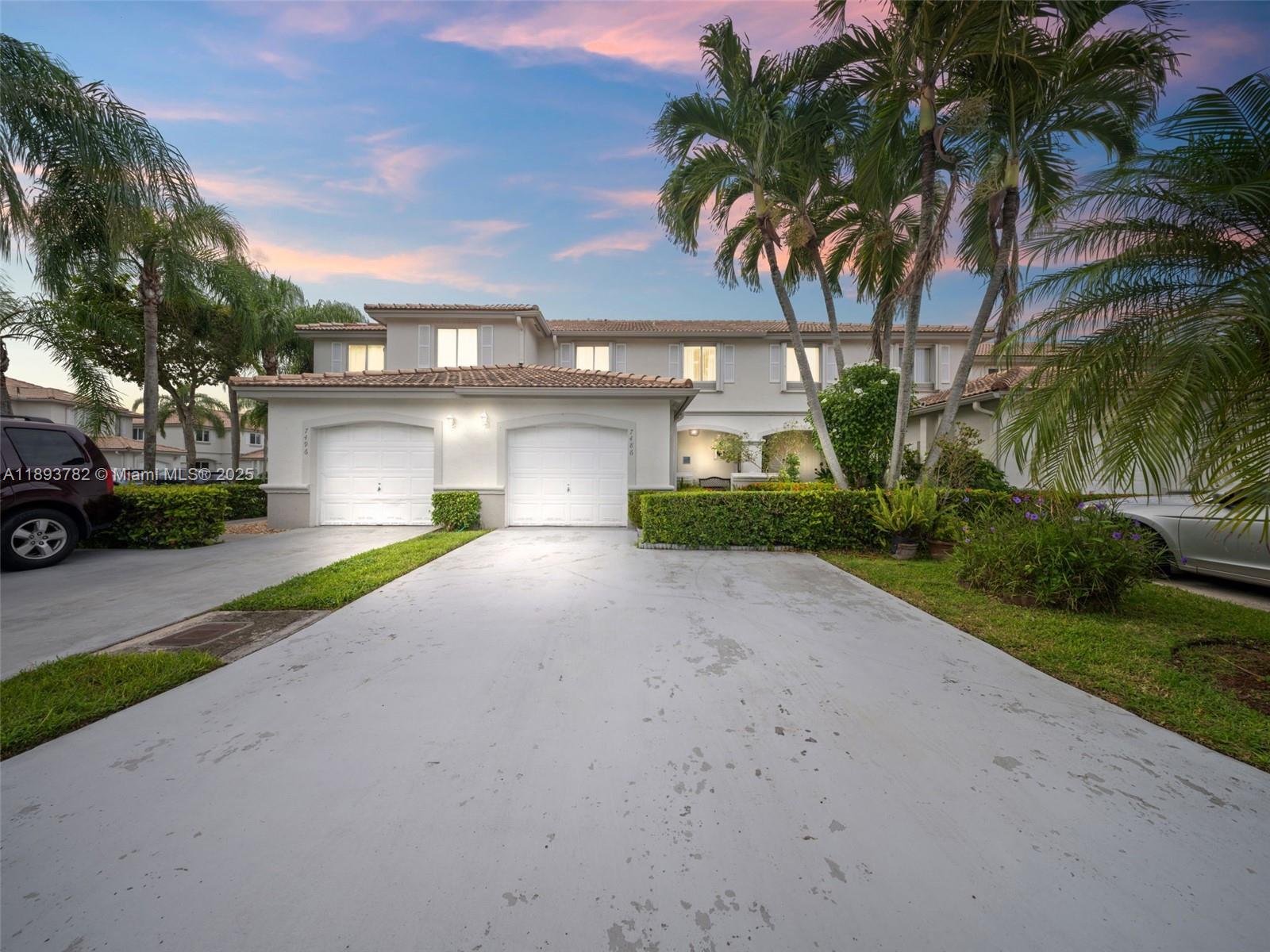 a view of a house with a yard and palm trees