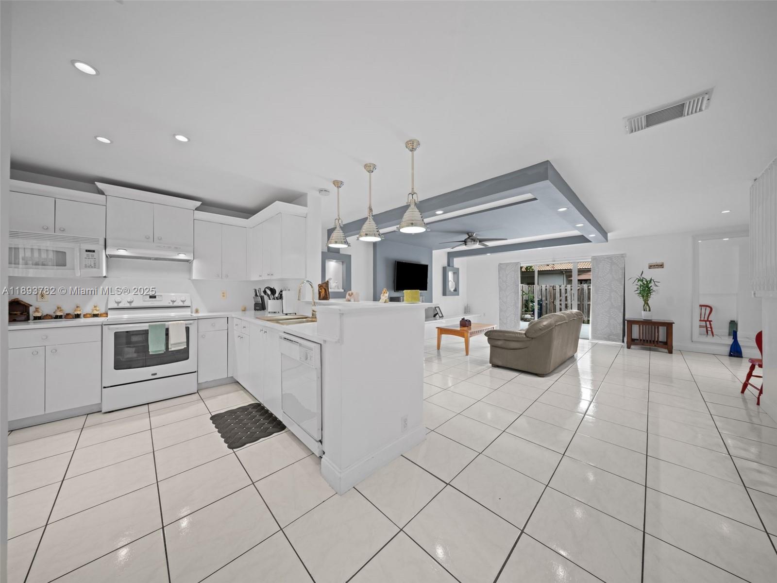 7486 Southwest 162nd Court Miami, FL 33193 - Photo 23 of 47 a kitchen with stainless steel appliances kitchen island granite countertop a sink and white cabinets