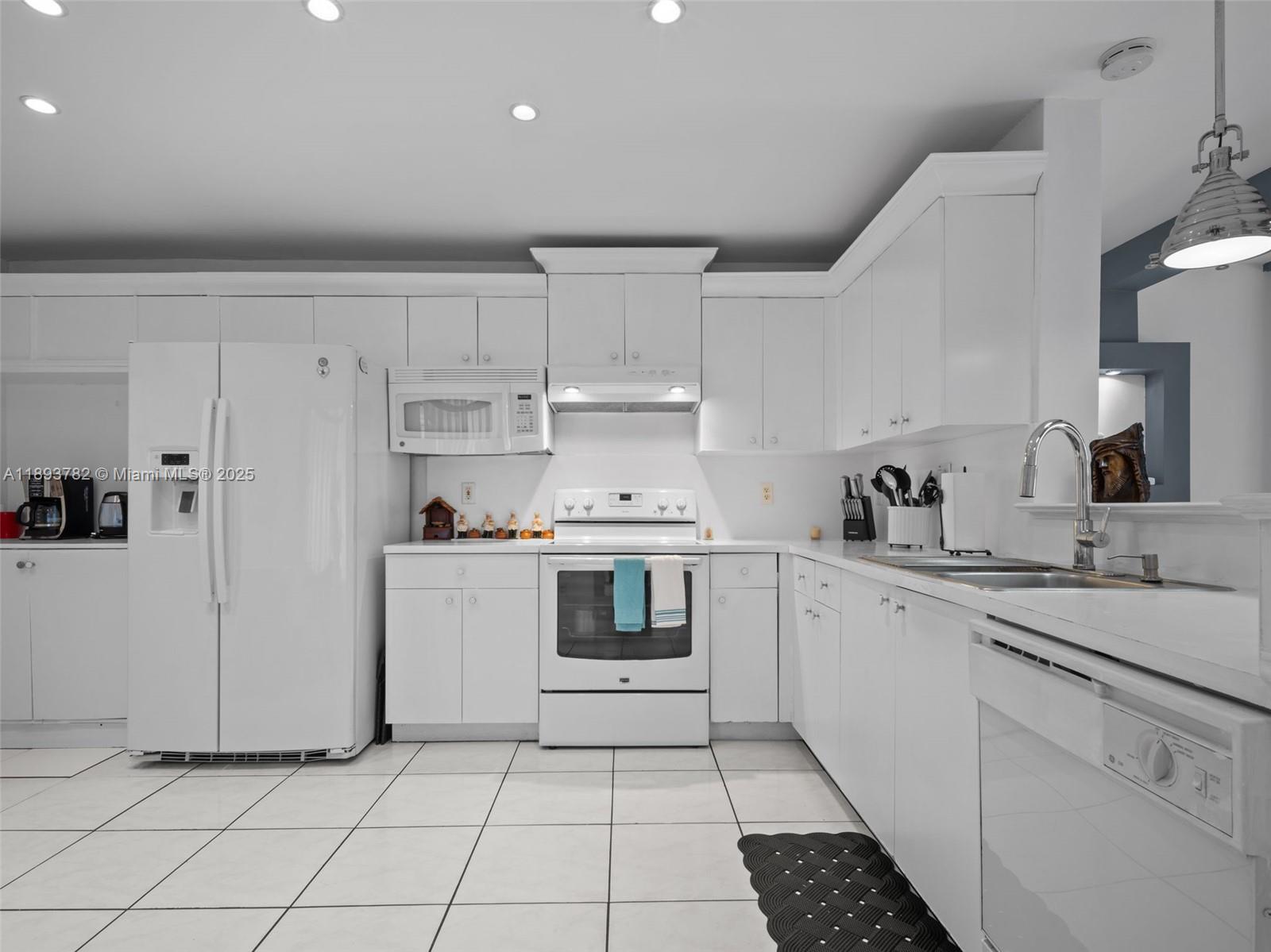 7486 Southwest 162nd Court Miami, FL 33193 - Photo 25 of 47 a kitchen with cabinets and white appliances