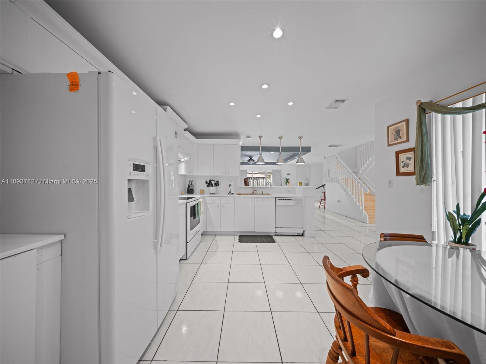 7486 Southwest 162nd Court Miami, FL 33193 - Photo 27 of 47 a large white kitchen with cabinets and wooden floor