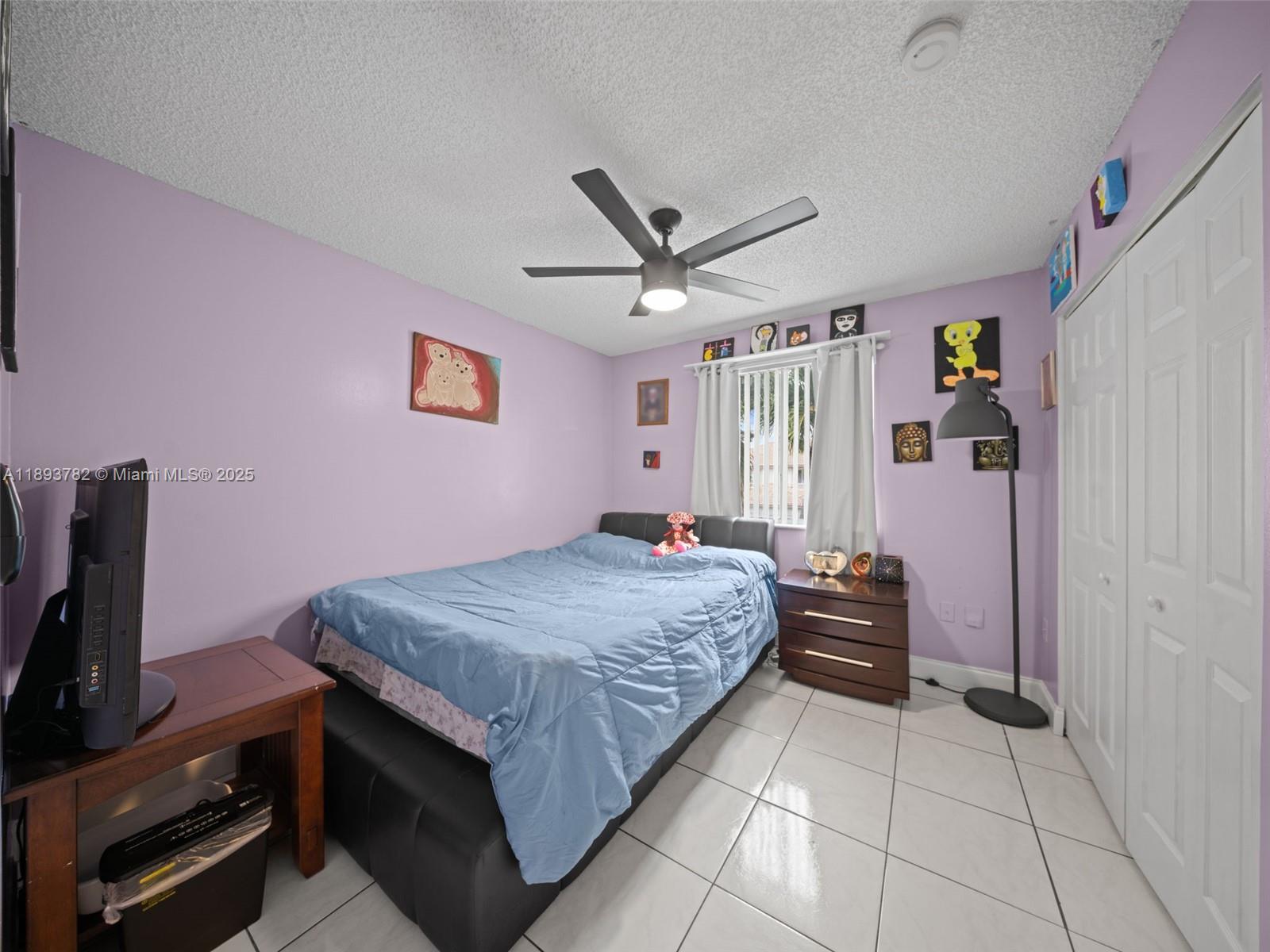 7486 Southwest 162nd Court Miami, FL 33193 - Photo 32 of 47 a bedroom with a bed and a flat screen tv