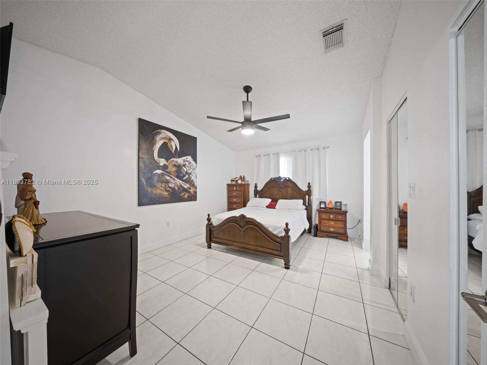 7486 Southwest 162nd Court Miami, FL 33193 - Photo 36 of 47 a bedroom with a bed and a chandelier