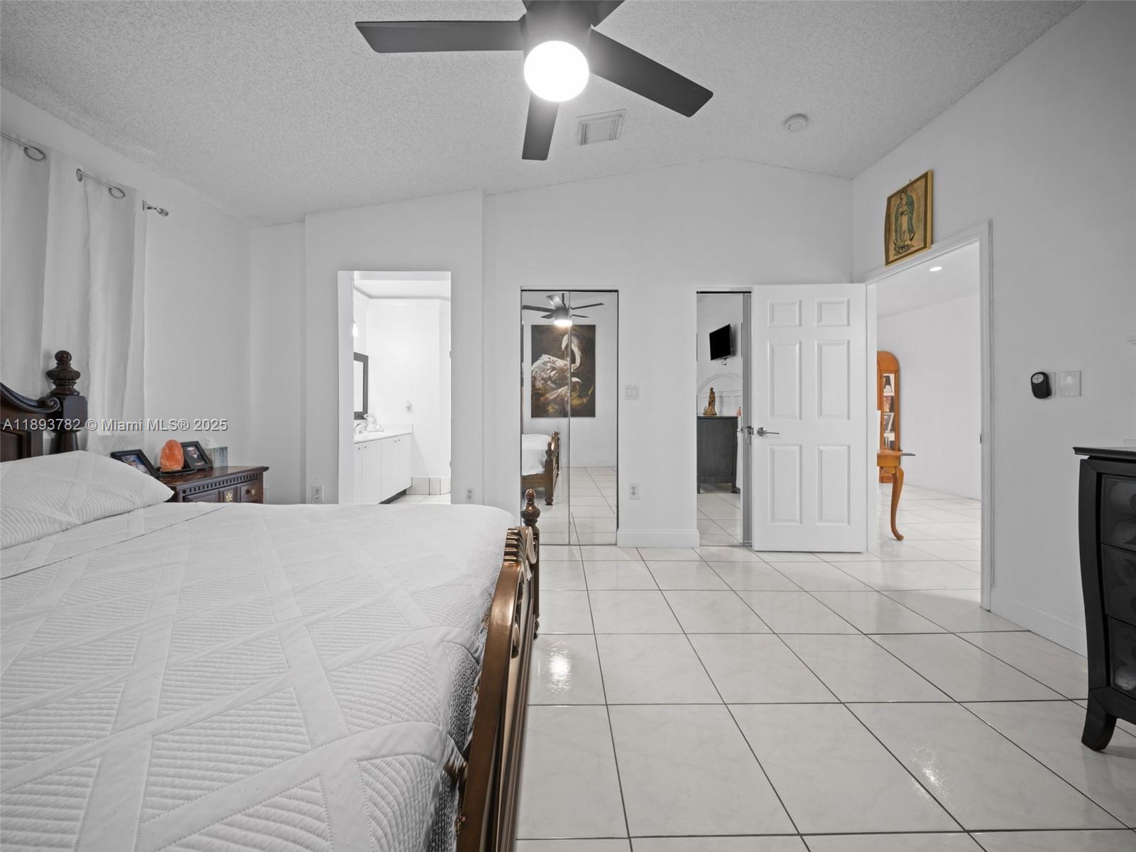 7486 Southwest 162nd Court Miami, FL 33193 - Photo 40 of 47 a spacious bedroom with a bed and a chandelier