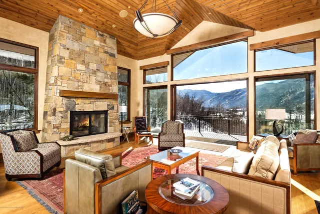 a living room with furniture a fireplace and a floor to ceiling window