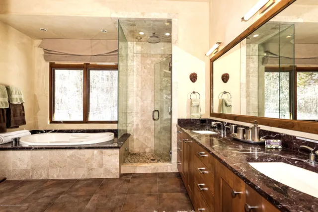 a bathroom with a granite countertop sink mirror and a bathtub