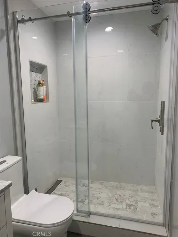 a white toilet sitting next to a shower