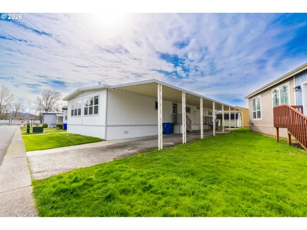 a view of an house with backyard space and balcony