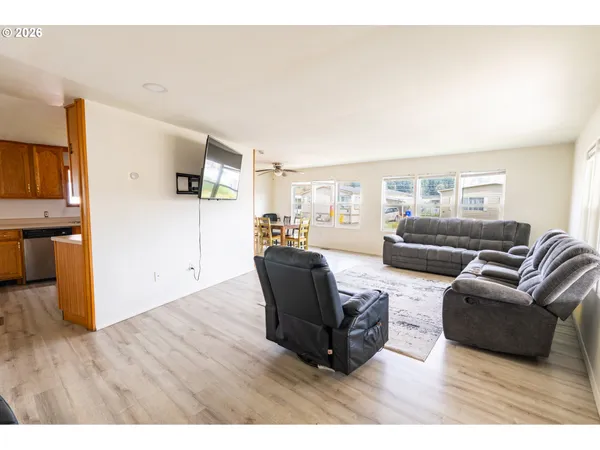 a living room with furniture a flat screen tv and a wooden floor
